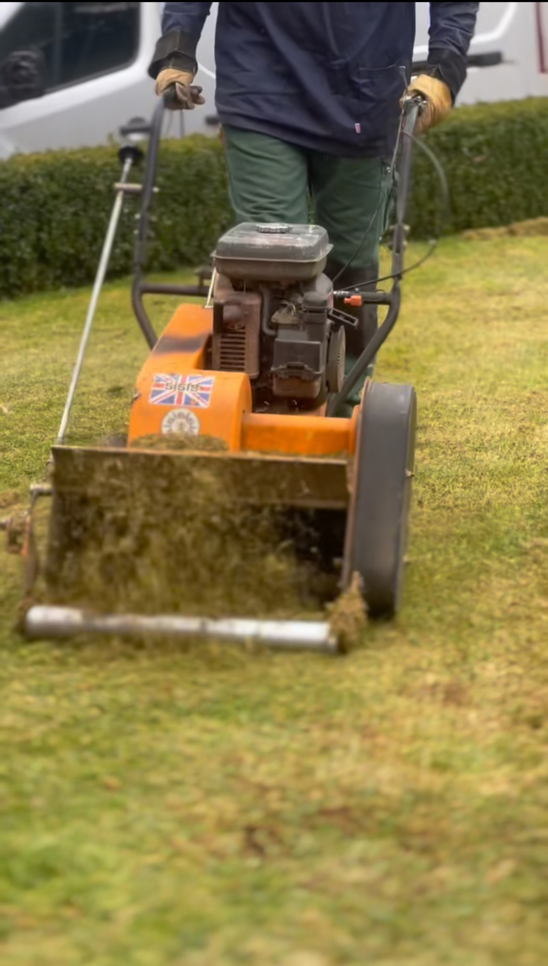 Professional petrol scarifier renovating a tired lawn